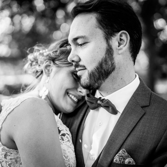 Couple de mariés enlacés tendrement - Photographie en noir et blanc